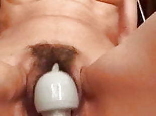 Wand inserted in hairy pussy