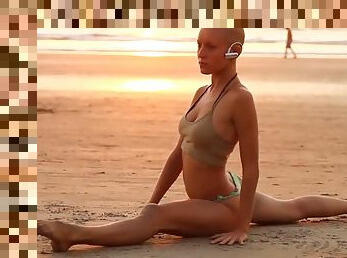 Bald yogi girl on the beach