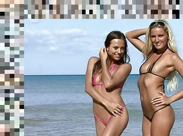 Two hot babes posing on the beach in a tiny bikini