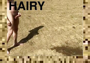 The hairy guy shoots a tight stream of piss high on the field. Man pissing in nature