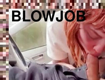 Red-haired beauty gives a blowjob in the car