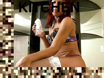 Redhead tranny in a colorful bikini masturbates in the kitchen