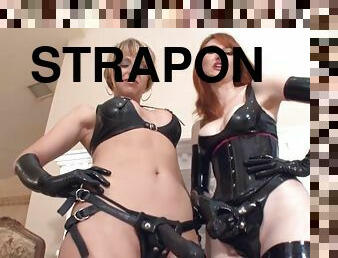 Two latex sluts with strap-ons teasing her asshole