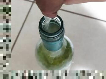 Filling up a 750mL bottle of wine with piss